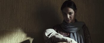 Movie still from “American Sniper” (2014), directed by Clint Eastwood – A woman with a scarf on her arm; Close Up shot, Low angle