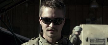 Movie still from “American Sniper” (2014), directed by Clint Eastwood – A person wearing sunglasses; Close Up shot, Low angle