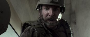 Movie still from “American Sniper” (2014), directed by Clint Eastwood – A person wearing a helmet; Close Up shot, Over the shoulder angle