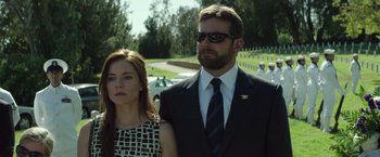 Movie still from “American Sniper” (2014), directed by Clint Eastwood – A man and a woman standing next to each other; Medium shot, Over the shoulder angle