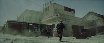 Movie still from “American Sniper” (2014), directed by Clint Eastwood – Two men are walking through a dusty area; Wide shot, Low angle