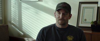Movie still from “American Sniper” (2014), directed by Clint Eastwood – A person wearing a hat; Close Up shot, Over the shoulder angle