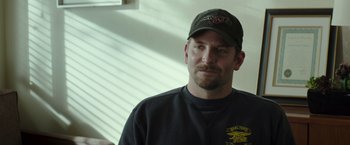 Movie still from “American Sniper” (2014), directed by Clint Eastwood – A person wearing a hat; Close Up shot, Over the shoulder angle