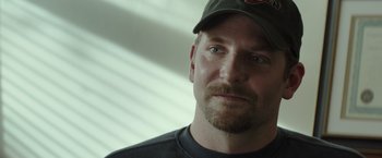 Movie still from “American Sniper” (2014), directed by Clint Eastwood – A person wearing a hat; Close Up shot, Over the shoulder angle