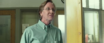 Movie still from “American Sniper” (2014), directed by Clint Eastwood – An older man wearing glasses and a plaid shirt; Close Up shot, Low angle