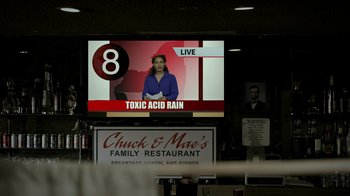 Movie still from “Amityville Uprising” (2022), directed by Thomas J. Churchill – A television screen showing a news program about acid rain; Medium shot, Low angle