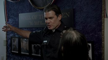 Movie still from “Amityville Uprising” (2022), directed by Thomas J. Churchill – A man in a police uniform talking to a woman; Medium shot, Over the shoulder angle