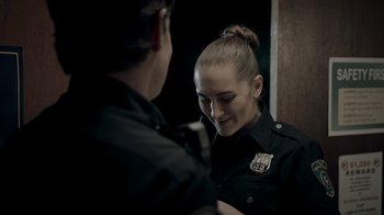 Movie still from “Amityville Uprising” (2022), directed by Thomas J. Churchill – A police officer smiles at a man in a uniform; Close Up shot, Over the shoulder angle