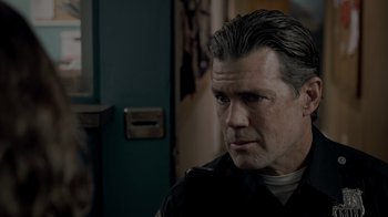 Movie still from “Amityville Uprising” (2022), directed by Thomas J. Churchill – A person wearing a police uniform; Close Up shot, Over the shoulder angle