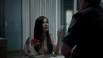 Movie still from “Amityville Uprising” (2022), directed by Thomas J. Churchill – A woman sitting in front of a mirror holding a paper plane; Medium shot, Over the shoulder angle