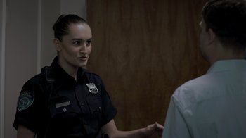 Movie still from “Amityville Uprising” (2022), directed by Thomas J. Churchill – A police officer in uniform is looking at the camera; Close Up shot, Over the shoulder angle