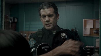 Movie still from “Amityville Uprising” (2022), directed by Thomas J. Churchill – A man in a police uniform looking at the camera; Close Up shot, Over the shoulder angle
