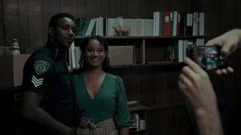 Movie still from “Amityville Uprising” (2022), directed by Thomas J. Churchill – A man and a woman posing for a picture in a room; Medium shot, Over the shoulder angle