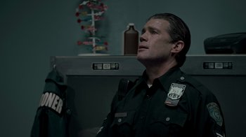 Movie still from “Amityville Uprising” (2022), directed by Thomas J. Churchill – A man in a police uniform looking up; Medium shot, Low angle
