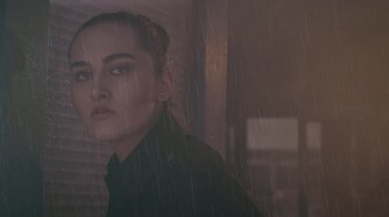 Movie still from “Amityville Uprising” (2022), directed by Thomas J. Churchill – A woman standing in the rain looking at the camera; Close Up shot, Low angle