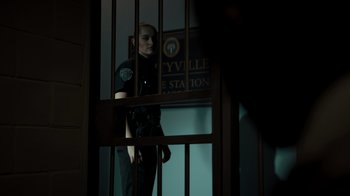 Movie still from “Amityville Uprising” (2022), directed by Thomas J. Churchill – A man standing behind bars in a jail cell; Medium shot, Over the shoulder angle