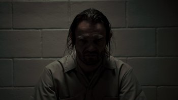 Movie still from “Amityville Uprising” (2022), directed by Thomas J. Churchill – A man with long black hair and a beard; Close Up shot, High angle