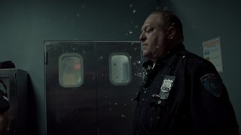 Movie still from “Amityville Uprising” (2022), directed by Thomas J. Churchill – A police officer standing in front of an airplane window; Close Up shot, Low angle