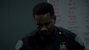 Movie still from “Amityville Uprising” (2022), directed by Thomas J. Churchill – A police officer is looking down at his face; Close Up shot, Over the shoulder angle