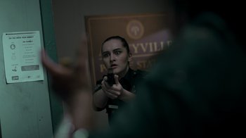 Movie still from “Amityville Uprising” (2022), directed by Thomas J. Churchill – A police officer taking a picture of herself with her cell phone; Close Up shot, Over the shoulder angle