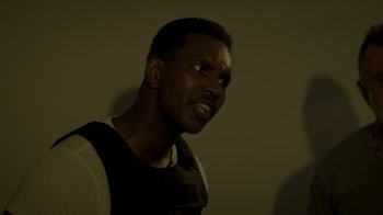 Movie still from “Amityville Uprising” (2022), directed by Thomas J. Churchill – A man with a black shirt is looking at the camera; Close Up shot, Low angle