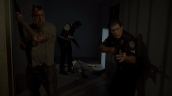 Movie still from “Amityville Uprising” (2022), directed by Thomas J. Churchill – A group of men standing next to each other in a room; Wide shot, High angle