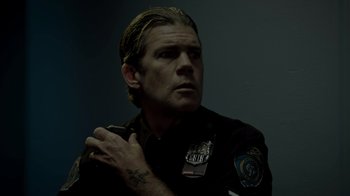 Movie still from “Amityville Uprising” (2022), directed by Thomas J. Churchill – A man with a tattoo on his arm is holding a cell phone; Close Up shot, Low angle