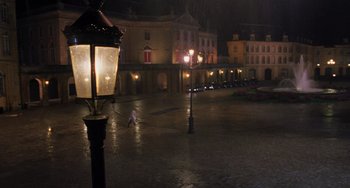 Movie still from “An American Werewolf in Paris” (1997), directed by Anthony Waller – A person walking in the rain near a street light; Extreme Wide shot, High angle