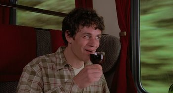 Movie still from “An American Werewolf in Paris” (1997), directed by Anthony Waller – A man holding a glass of wine in his hand; Medium shot, High angle
