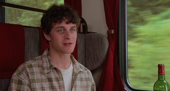Movie still from “An American Werewolf in Paris” (1997), directed by Anthony Waller – A man sitting on a train looking out the window; Close Up shot, Over the shoulder angle