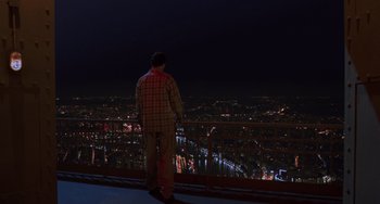 Movie still from “An American Werewolf in Paris” (1997), directed by Anthony Waller – A man standing on the edge of a building at night; Extreme Wide shot, High angle