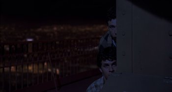 Movie still from “An American Werewolf in Paris” (1997), directed by Anthony Waller – Two young men sitting on top of a building at night; Medium shot, High angle