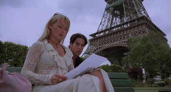 Movie still from “An American Werewolf in Paris” (1997), directed by Anthony Waller – A man and a woman sitting in front of the eiffel tower looking at papers; Medium shot, Low angle