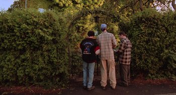 Movie still from “An American Werewolf in Paris” (1997), directed by Anthony Waller – A group of men standing next to each other near trees; Wide shot, Over the shoulder angle