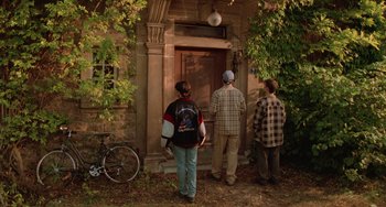 Movie still from “An American Werewolf in Paris” (1997), directed by Anthony Waller – A group of young men standing in front of a building; Wide shot, Over the shoulder angle