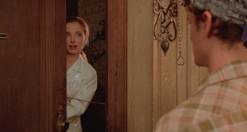 Movie still from “An American Werewolf in Paris” (1997), directed by Anthony Waller – A woman standing in front of a mirror; Medium shot, Over the shoulder angle