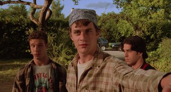 Movie still from “An American Werewolf in Paris” (1997), directed by Anthony Waller – A group of young men standing next to each other on a street; Medium shot, Low angle