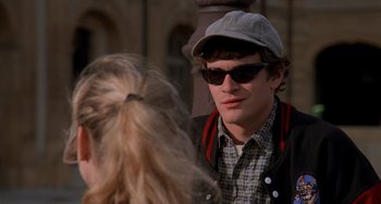 Movie still from “An American Werewolf in Paris” (1997), directed by Anthony Waller – A young man wearing a hat and sunglasses; Medium shot, Over the shoulder angle