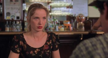 Movie still from “An American Werewolf in Paris” (1997), directed by Anthony Waller – A woman sitting at a table in front of a bar; Close Up shot, Over the shoulder angle