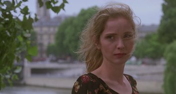 Movie still from “An American Werewolf in Paris” (1997), directed by Anthony Waller – A beautiful young woman with blonde hair standing next to a river; Close Up shot, Over the shoulder angle