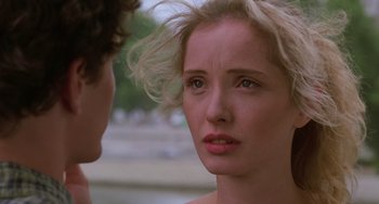 Movie still from “An American Werewolf in Paris” (1997), directed by Anthony Waller – A young woman looking at the camera while a man looks at her face; Close Up shot, Over the shoulder angle