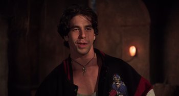 Movie still from “An American Werewolf in Paris” (1997), directed by Anthony Waller – A young man with long dark hair wearing a football jersey; Close Up shot, Over the shoulder angle