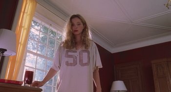 Movie still from “An American Werewolf in Paris” (1997), directed by Anthony Waller – A woman standing in front of a window in a room; Medium shot, Low angle