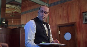 Movie still from “An American Werewolf in Paris” (1997), directed by Anthony Waller – A man holding a tray of food in front of him; Close Up shot, Low angle