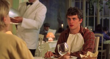 Movie still from “An American Werewolf in Paris” (1997), directed by Anthony Waller – A man sitting at a table with a glass of wine; Close Up shot, Over the shoulder angle