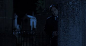 Movie still from “An American Werewolf in Paris” (1997), directed by Anthony Waller – A man standing next to a wall at night; Medium shot, Low angle