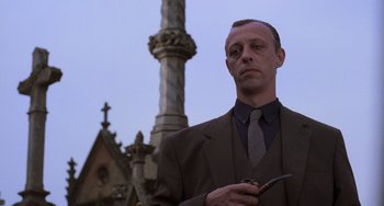 Movie still from “An American Werewolf in Paris” (1997), directed by Anthony Waller – A man standing in front of a building holding a cigarette; Close Up shot, Low angle
