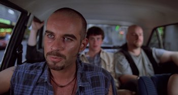 Movie still from “An American Werewolf in Paris” (1997), directed by Anthony Waller – A man with a goatee is in the back of a car; Close Up shot, Low angle