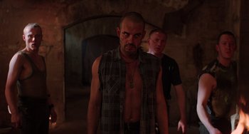 Movie still from “An American Werewolf in Paris” (1997), directed by Anthony Waller – A man in a plaid shirt standing next to another man in a black shirt; Medium shot, Low angle