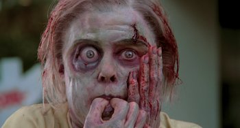 Movie still from “An American Werewolf in Paris” (1997), directed by Anthony Waller – A woman with a zombie makeup on her face and hands; Close Up shot, Low angle